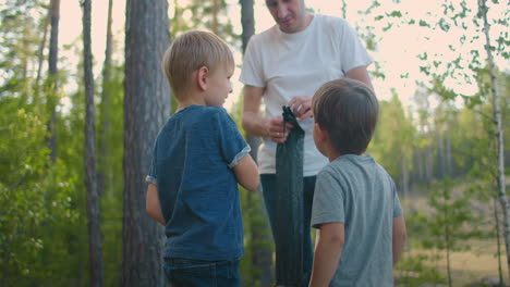 Father-and-two-sons-3-5-years-together-on-a-hike-set-up-a-tent